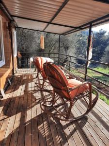 2 mecedoras sentadas en una terraza de madera en Field Of Possibilites - Kayakoy Retreat, en Kayakoy