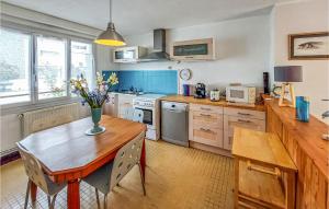 a kitchen with a wooden table with a vase of flowers on it at Stunning Home In Saint-nazaire With Wifi in Saint-Nazaire