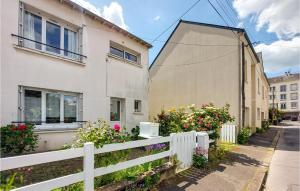 a white fence in front of a house with flowers at Stunning Home In Saint-nazaire With Wifi in Saint-Nazaire