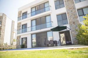 a building with a table and an umbrella in front of it at PETRUM SUNSET RESİDENCE HOTEL in Bodrum City