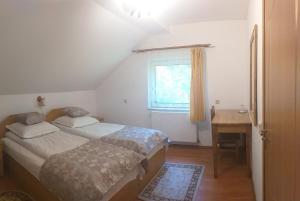 スチェヴィツァにあるȘoaptele pădurii & Căsuța din pădureのベッドルーム1室(ベッド2台、デスク、窓付)