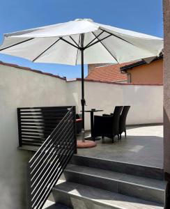 un patio con mesa y sombrilla en Apartman Star #1 en Vinkovci