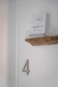 un número cuatro en una pared blanca con una caja en Aggelikoula Rooms en Tinos Town