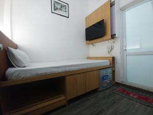 Habitación pequeña con cama y TV. en Hanoi Discovery Hotel, en Hanói