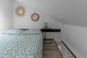 een slaapkamer met een bed en een tafel met een spiegel bij Résidence Le Celest - Appartements climatisés - Centre ville in Vichy