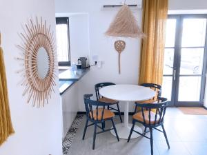 a dining room with a white table and chairs at Résidence du Platane in Saint-Laurent-des-Arbres