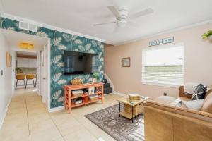 a living room with a couch and a tv at Crescent Beach Bungalow B in Saint Augustine