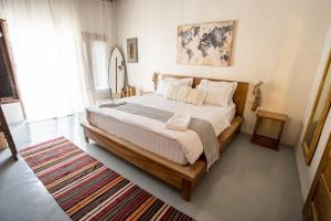 1 dormitorio con 1 cama grande y 1 alfombra en Dylan’s Retreat, en Lasikin