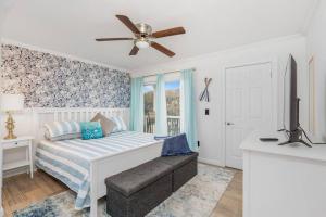 a bedroom with a bed with a ceiling fan at Crescent Beach Bungalow B in Saint Augustine