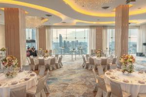 a banquet hall with white tables and chairs and windows at Pullman Bangkok Hotel G in Bangkok