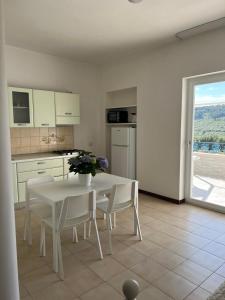 Una cocina blanca con una mesa y sillas blancas. en Residence Paradise, en Peschici