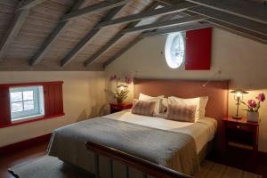 um quarto com uma cama grande e uma janela em Quinta das Vinhas na Calheta