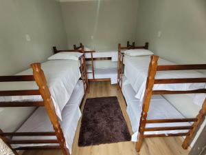 three bunk beds in a room with wooden floors at Espaço Colibri in Ribeirão Preto
