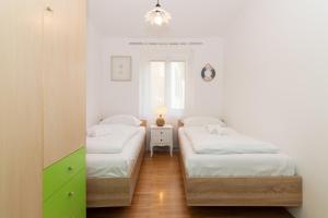 1 Schlafzimmer mit 2 Einzelbetten und einem Spiegel in der Unterkunft Casa della Fortuna by Locap Group in Piran