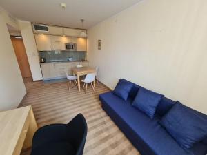 華沙的住宿－10Q - Z6 Apartment 303，一间带蓝色沙发的客厅和一间厨房