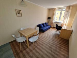 華沙的住宿－10Q - Z6 Apartment 303，客厅配有桌子和蓝色沙发