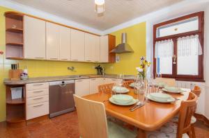 eine Küche mit einem Holztisch und eine Küche mit gelben Wänden in der Unterkunft Casa della Fortuna by Locap Group in Piran