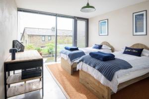 2 camas en un dormitorio con ventana grande en Quarry House, en Kingsbridge