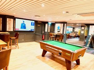 a game room with a pool table and a tv at The Kirkhouse Inn in Strathblane