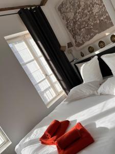 a bedroom with a bed with two red pillows on it at Auberge de la rose in Anet