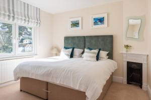 a bedroom with a large bed with white sheets and blue pillows at Old Sail Loft in Salcombe