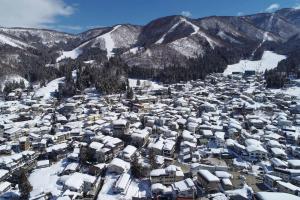 una vista aerea di una stazione sciistica coperta di neve di Kihachikan North Nozawa Onsen a Nozawa Onsen