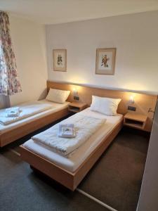 two twin beds in a room with two lamps at Pension Benedikt in Aschau am Inn