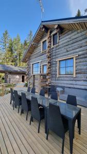 una terraza con mesa y sillas y una cabaña de madera en Villa Kaunisvirta, 