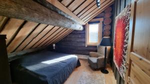 1 dormitorio con 1 cama y 1 silla en una cabaña en Villa Kaunisvirta 