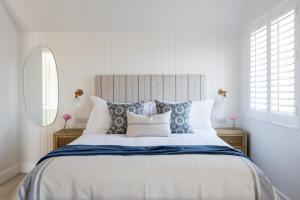 a bedroom with a large bed with blue and white pillows at Sanderling in Salcombe