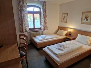 ein Hotelzimmer mit 2 Betten und einem Fenster in der Unterkunft Pension Benedikt in Aschau am Inn