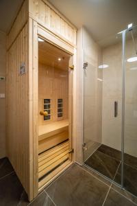 uma cabina de duche ao nível do chão numa casa de banho com painéis de madeira em Molo Lipno Apartment B201 Lipno Home em Lipno nad Vltavou