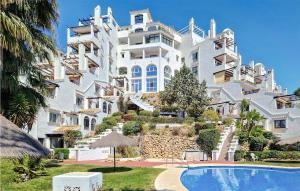 ミハス・コスタにあるAmazing Apartment In Mijas Costa With Swimming Poolの白い大きな建物で、目の前にプールがあります。