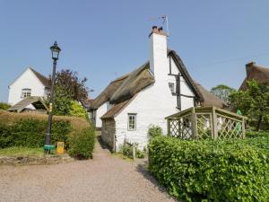 an old white house with a thatched roof at Bluebell Cottage in Stratford-upon-Avon