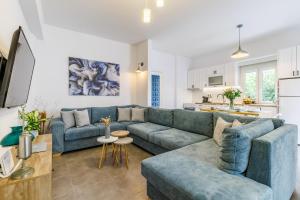 a living room with a blue couch and a kitchen at Servani Apartment in Skopelos Town