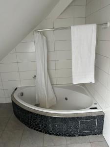 a bathroom with a bath tub with a towel at M-Hostel in Lucerne