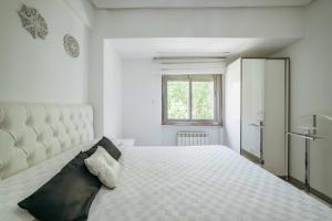 a white bedroom with a large bed in a room at Jardines de la Encarnación in Zamora