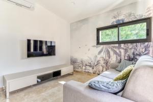 uma sala de estar com um sofá e uma televisão em L'appenti em Luc-sur-Orbieu