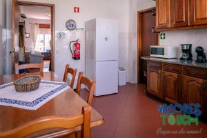 プライア・ダ・ヴィトーリアにあるCasa do Miranteのテーブルと白い冷蔵庫のあるキッチン +14枚の写真