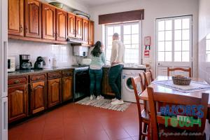 a man and a woman standing in a kitchen at Casa do Mirante in Praia da Vitória