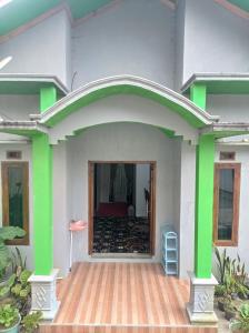 een huis met groene en witte muren bij Daratan Dieng in Diyeng