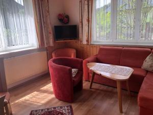 a living room with a red couch and a table at Waldhaus in Hinterstoder