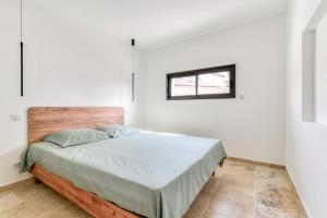 um quarto com uma cama num quarto branco em L'appenti em Luc-sur-Orbieu