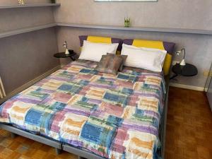 a bed with a colorful quilt in a bedroom at Milano Navigli Hideaway - 5 minutes from metro in Milan