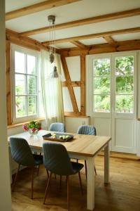 - une salle à manger avec une table, des chaises et des fenêtres dans l'établissement Haus Hedwig, à Heringsdorf