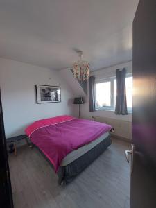 - une chambre avec un grand lit et une couverture rose dans l'établissement Wolu Room, à Bruxelles