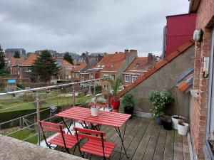 een rode tafel en stoelen op een balkon bij Wolu Room in Brussel