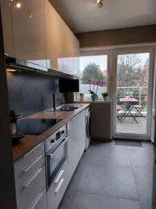 a kitchen with white appliances and a large window at Wolu Room in Brussels