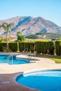 a swimming pool with a mountain in the background at Townhouse Azata Golf in Estepona