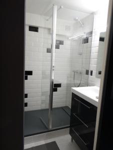 a shower with a glass door next to a sink at Appartement au calme proche d'un petit bois dans quimper in Quimper